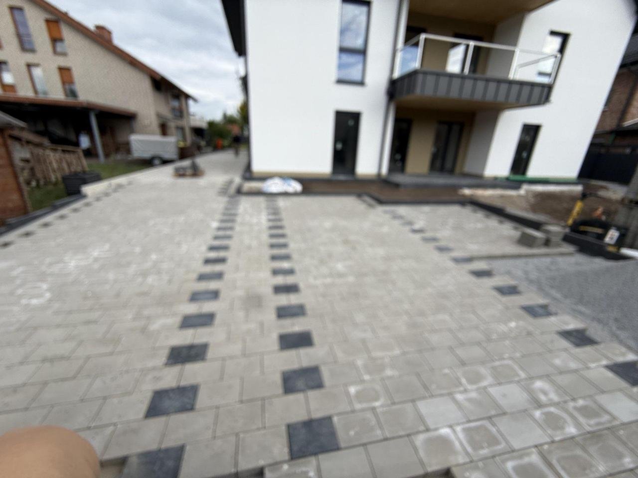 Gepflasterte Hofeinfahrt mit dunklem Zierband